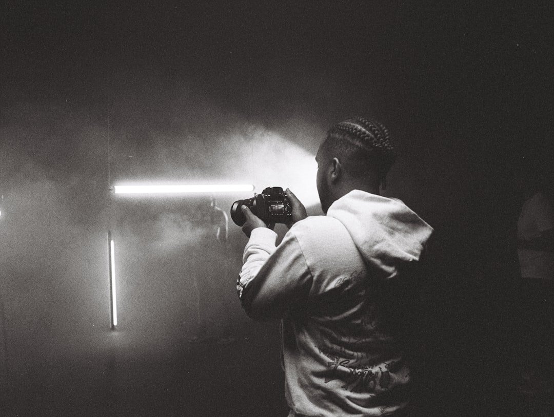 man in white dress shirt holding camera
