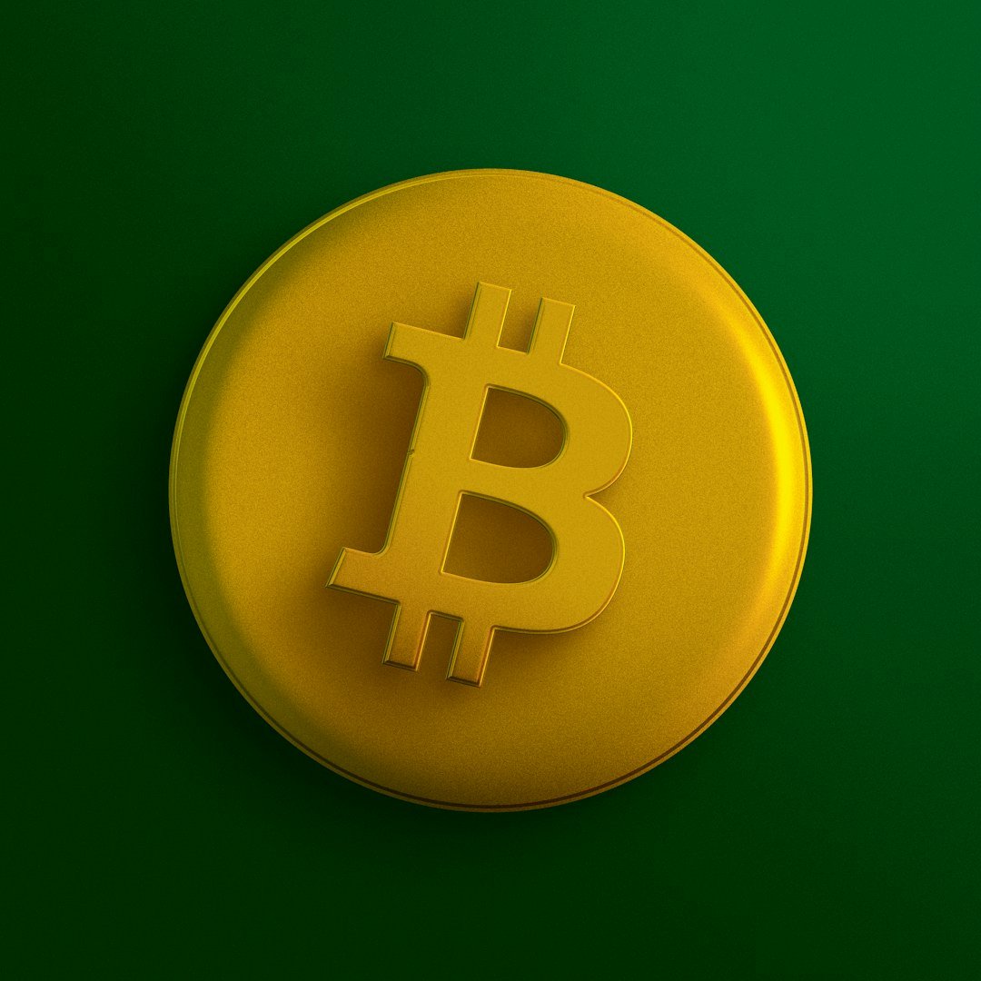a yellow bit coin sitting on top of a green surface